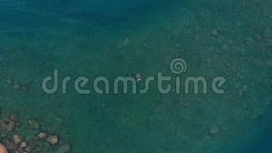 空中：漂浮在蓝色水面上的女人，在透明的地中海游泳，从上往下看，夏季度假